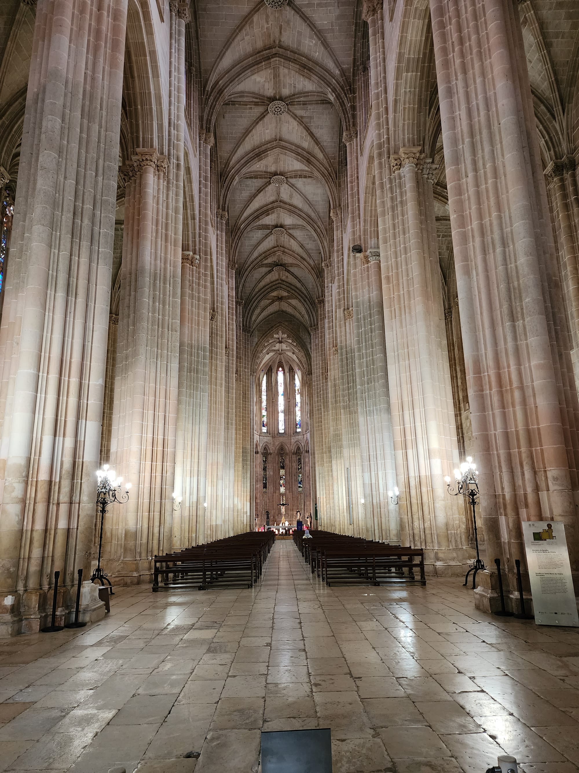 Sacred Silence: The vaulted ceilings and towering columns of a cathedral's nave stretch towards the heavens, enveloping the hushed pews in a serene embrace of stone and light.